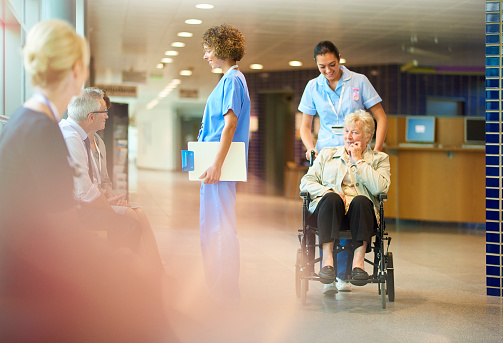 Nurse wheeling out a patient in a wheelchair