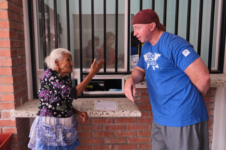 elderly woman from Honduras speaks with middle aged man