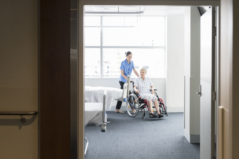 nurse pushing patient in wheelchair