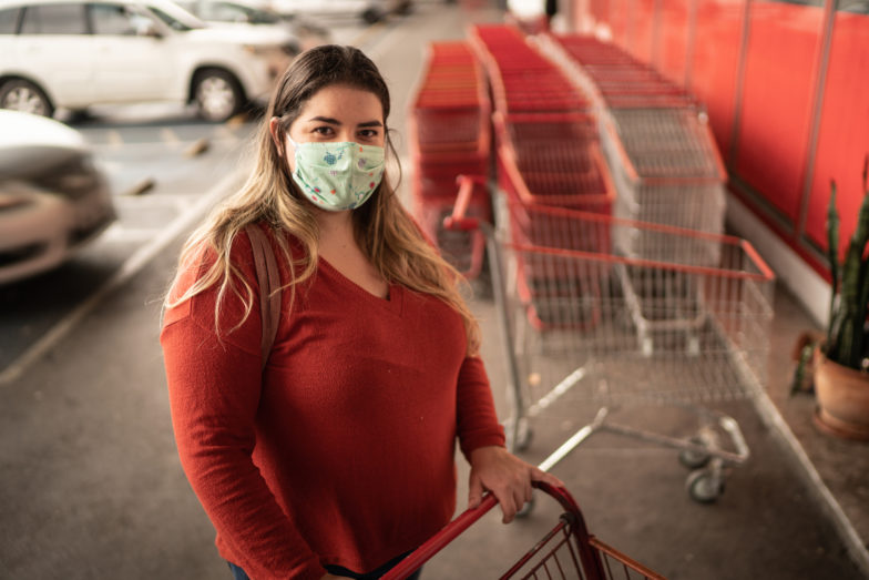 woman wearing a facemask with shopping cart