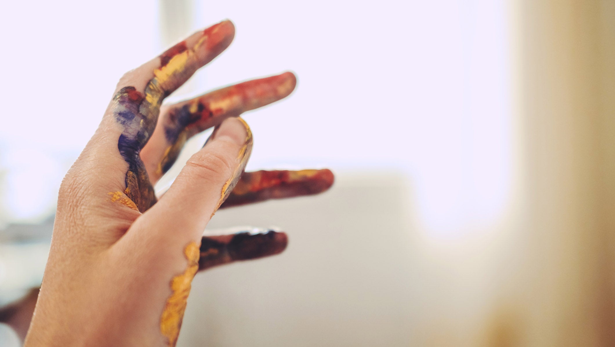 Woman hand in paint during finger painting.
